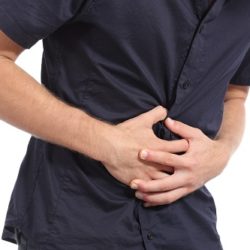Casual man with stomach ache isolated on a white background