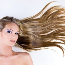 Beauty female face with long blond straight hair and bright blue make-up